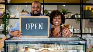 couple in a bakery with Open sign